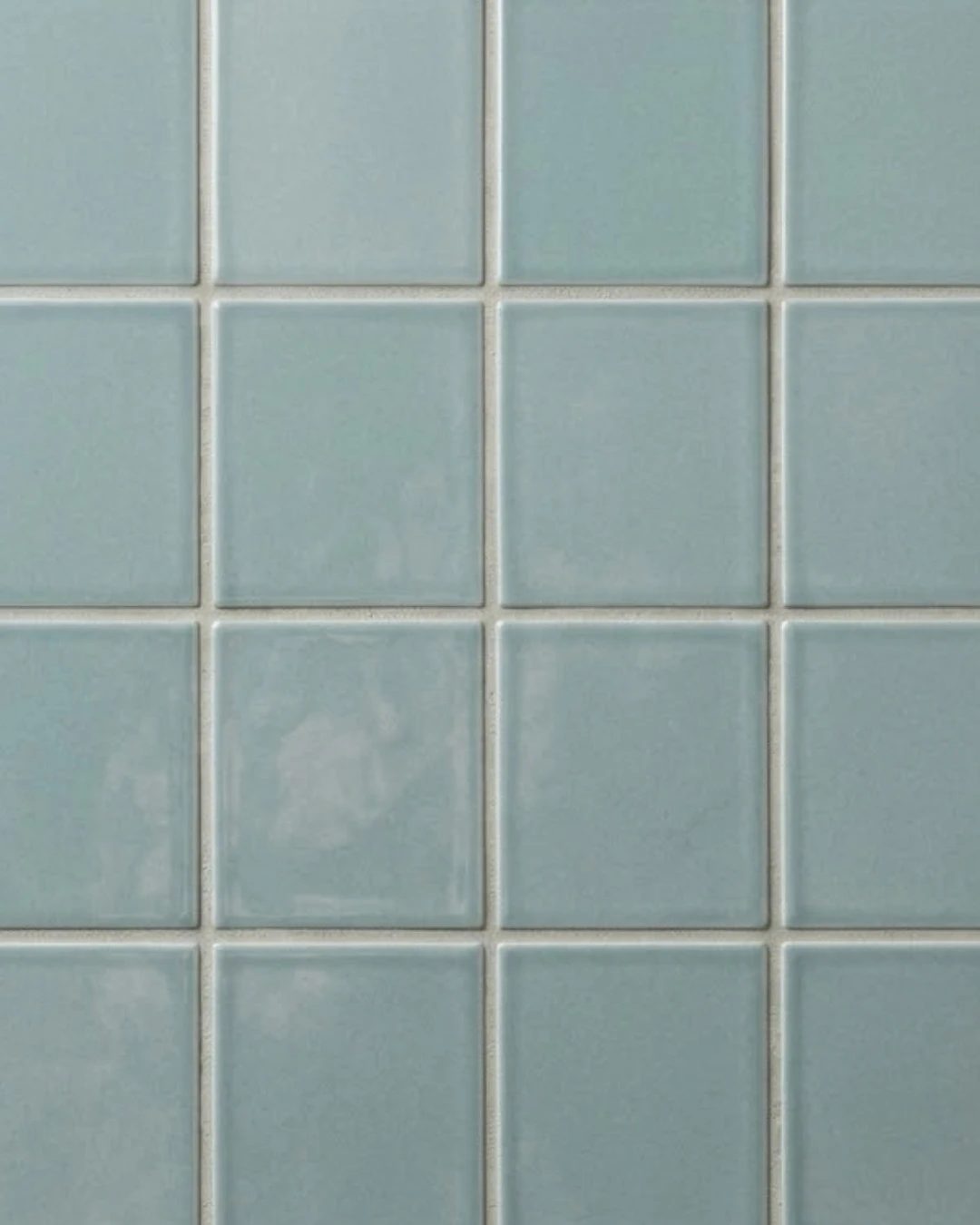 Un mur de carreaux émaillés bleu-vert pâle
